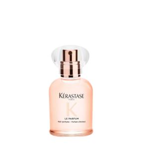 A bottle of Kérastase Paris Le Parfum hair perfume, featuring shimmering rose-gold accents and a clear cap, stands elegantly against a plain white background. This exquisite Gloss Absolu scent adds a luxurious final touch to your hair care routine. | Blush Salon Collective - Fargo, ND