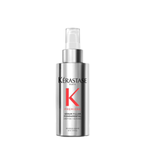 A silver bottle of Kérastase Paris Première Serum Filler Fondamental with a pump dispenser, shown against a plain white background, highlighting the luxurious design of this advanced serum filler. | Blush Salon Collective - Fargo, ND