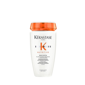 White bottle of Kérastase Nutritive Bain Satin shampoo with an orange cap, featuring the brand logo and product details on the front label, displayed against a plain background—an essential addition to any hair care routine. | Blush Salon Collective - Fargo, ND